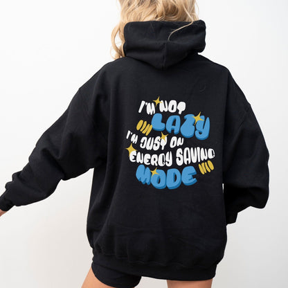 Back of a hoodie with the phrase “I’m Not Lazy, I’m Just on Energy Saving Mode” in playful retro typography. Cozy, unisex fit.