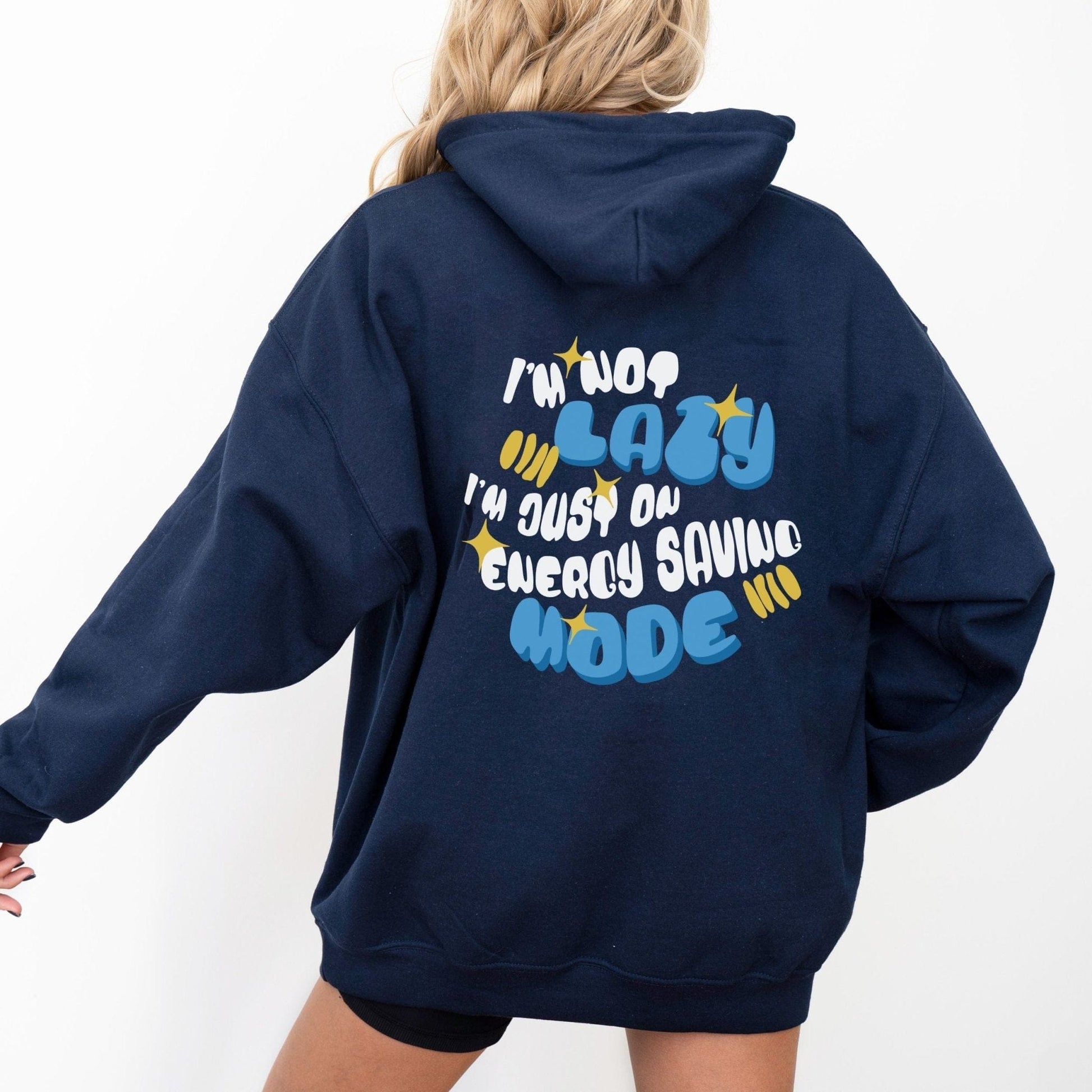 Back of a hoodie with the phrase “I’m Not Lazy, I’m Just on Energy Saving Mode” in playful retro typography. Cozy, unisex fit.