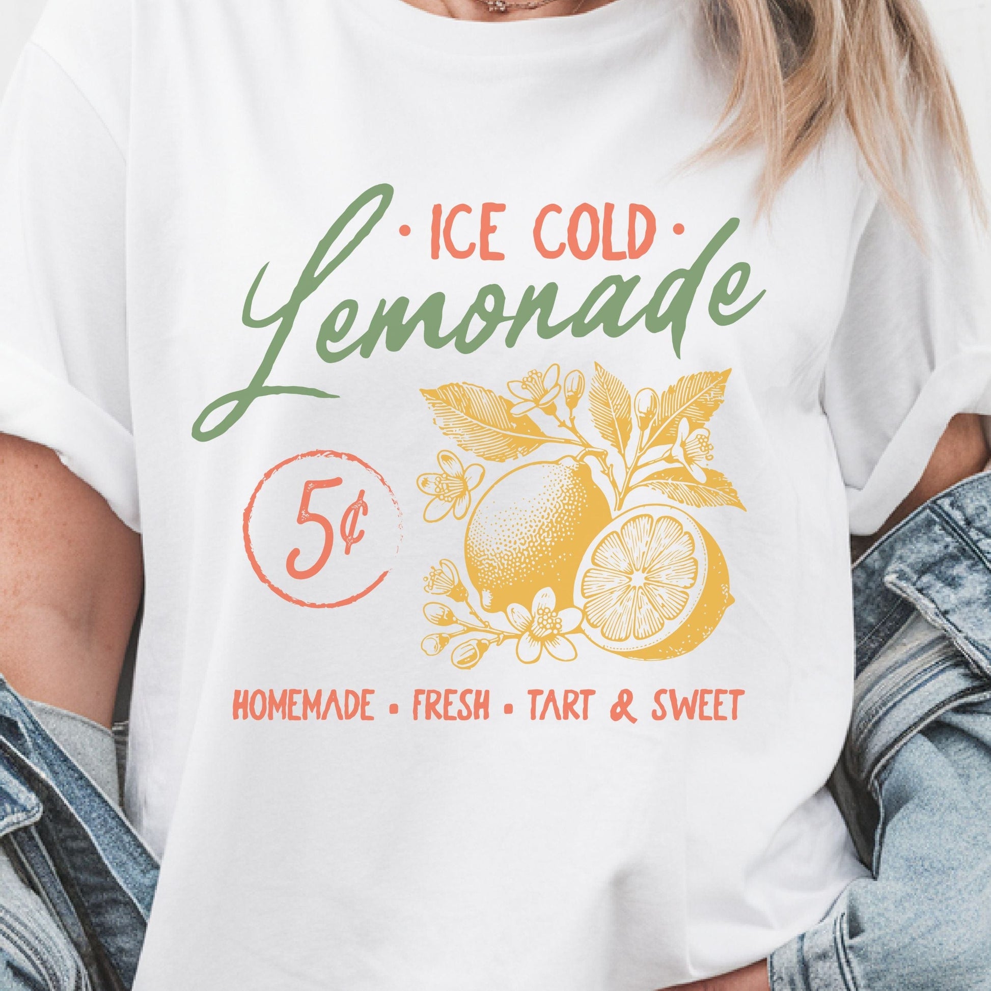 T-shirt design featuring vintage-style "Ice Cold Lemonade" text with yellow lemons, floral details, and a 5¢ sign for a retro summer vibe.