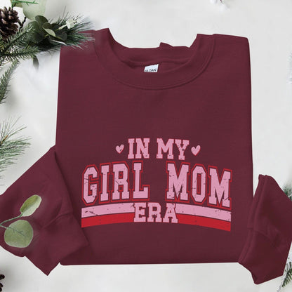 Sweatshirt with “In My Girl Mom Era” text in varsity pink and red lettering — bold and playful design for moms of daughters.