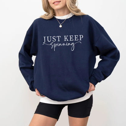 "Just Keep Spinning" sweatshirt from That Cozy Vibe, perfect for fitness and motivation.