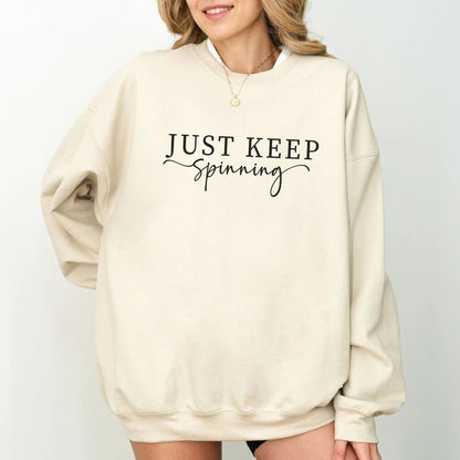 "Just Keep Spinning" sweatshirt from That Cozy Vibe, perfect for fitness and motivation.