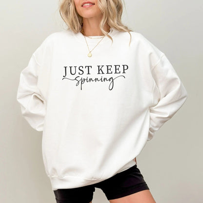 "Just Keep Spinning" sweatshirt from That Cozy Vibe, perfect for fitness and motivation.