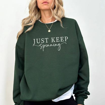 "Just Keep Spinning" sweatshirt from That Cozy Vibe, perfect for fitness and motivation.