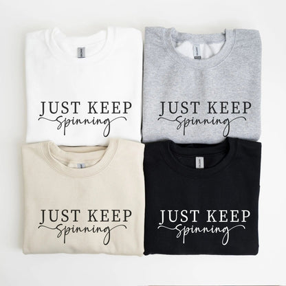 "Just Keep Spinning" sweatshirt from That Cozy Vibe, perfect for fitness and motivation.