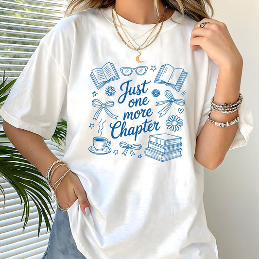 Just One More Chapter t-shirt in a cozy book lover aesthetic with bows, books, and daisies on front design
