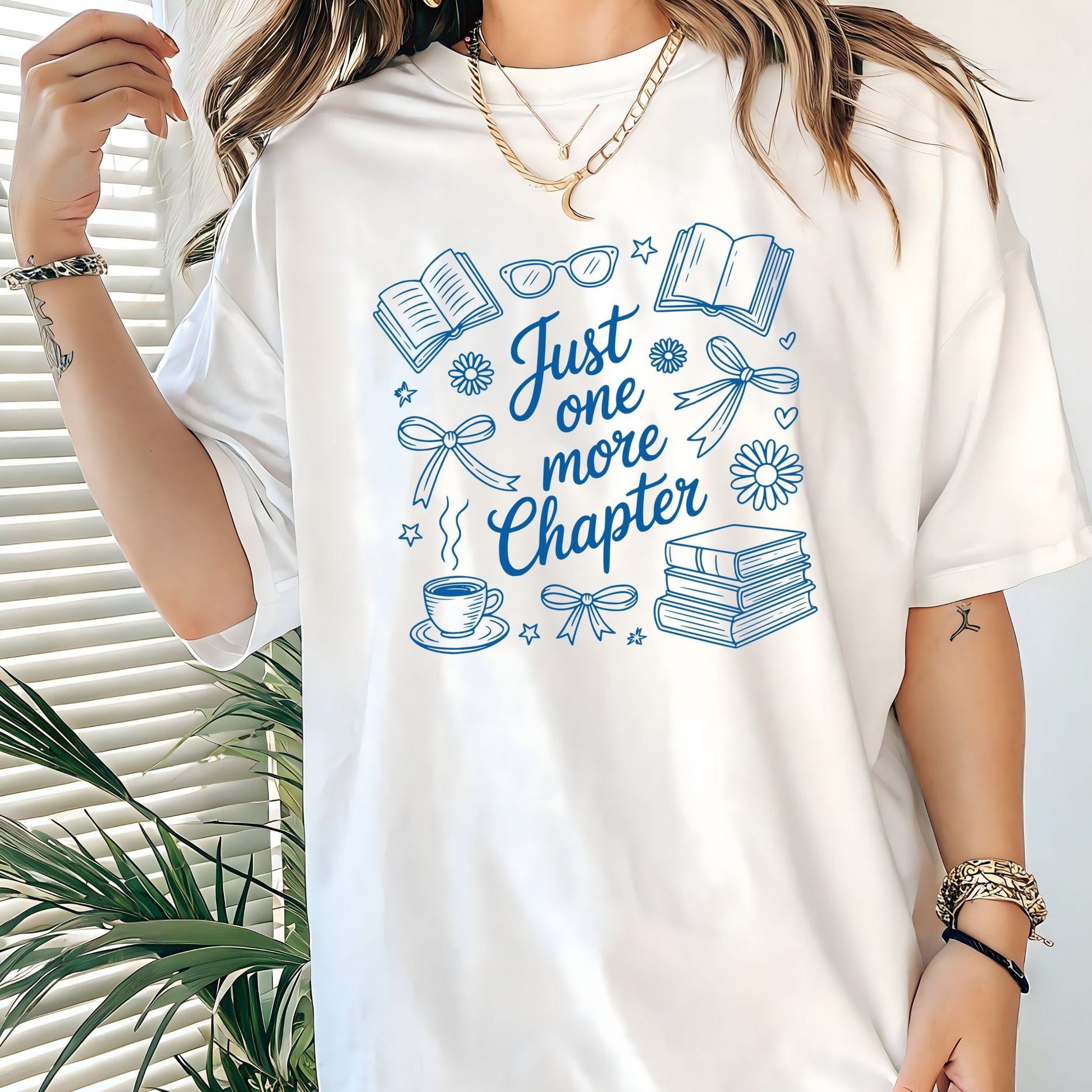 Just One More Chapter t-shirt in a cozy book lover aesthetic with bows, books, and daisies on front design