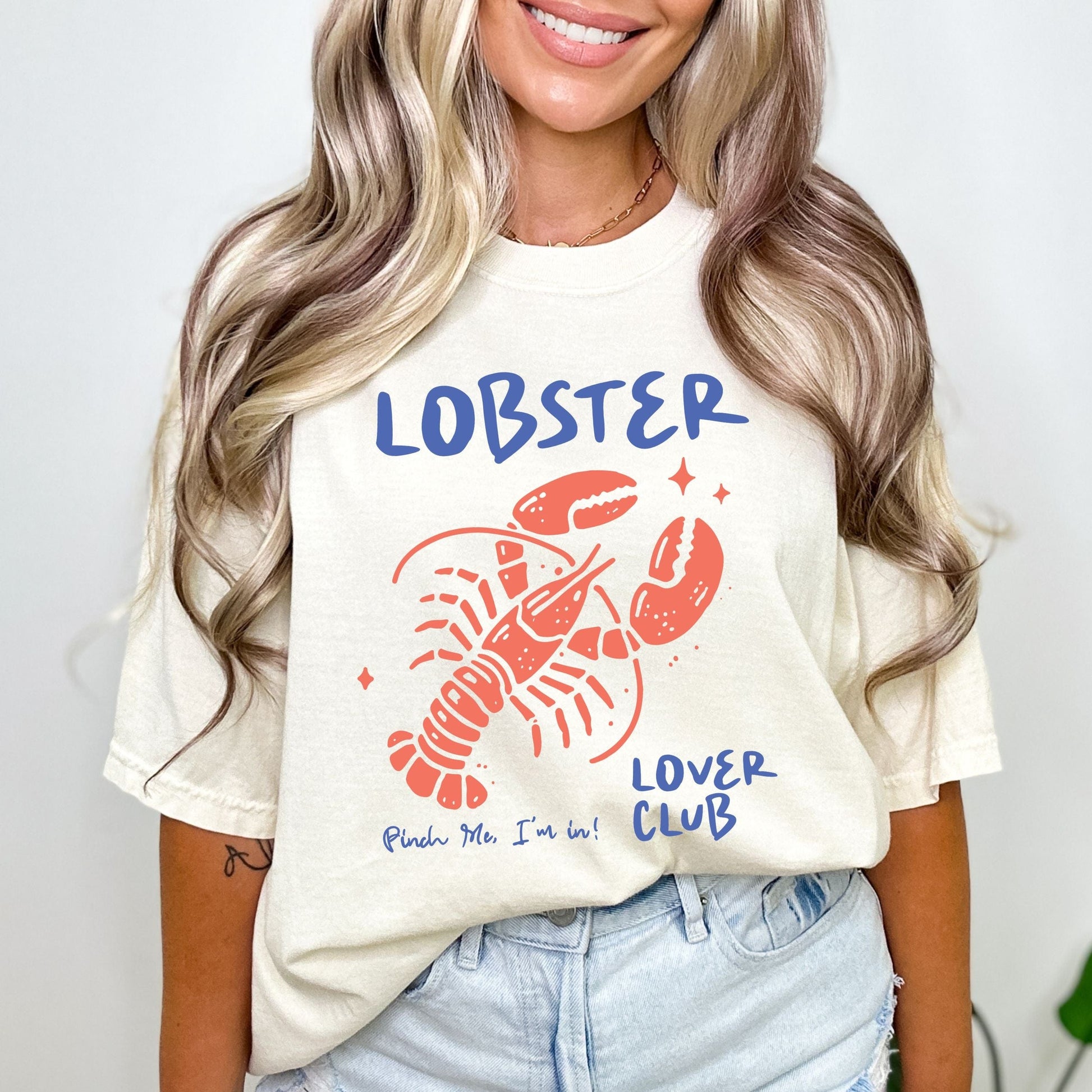 Colorful cartoon lobster with the phrase "Lobster Lover Club – Pinch Me, I'm In!" on a fun summer t-shirt for seafood and beach lovers.