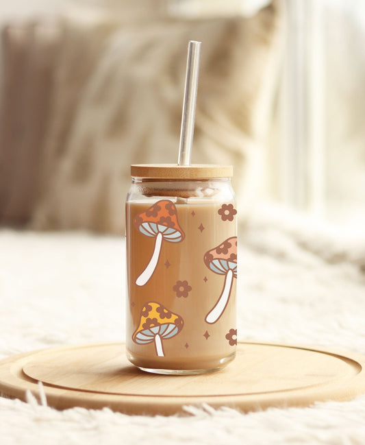 Whimsical mushroom and floral glass tumbler with lid and straw, perfect for retro boho cottagecore style.