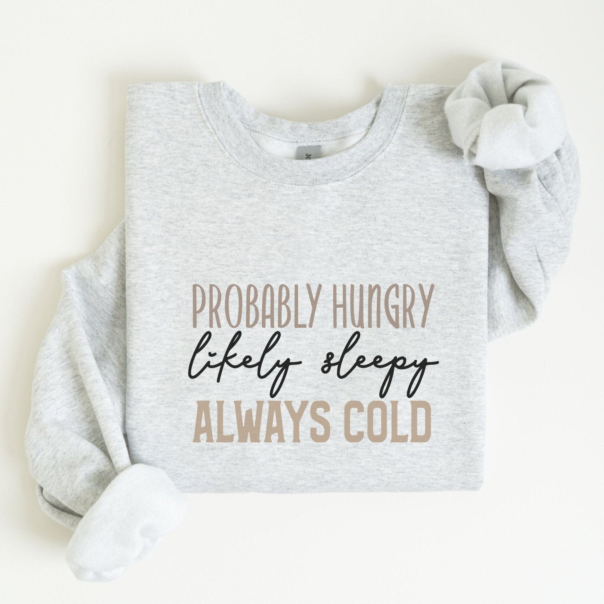 Funny “Probably Hungry, Always Cold” sweatshirt with neutral text on a cozy crewneck — perfect for comfort lovers and snack queens.