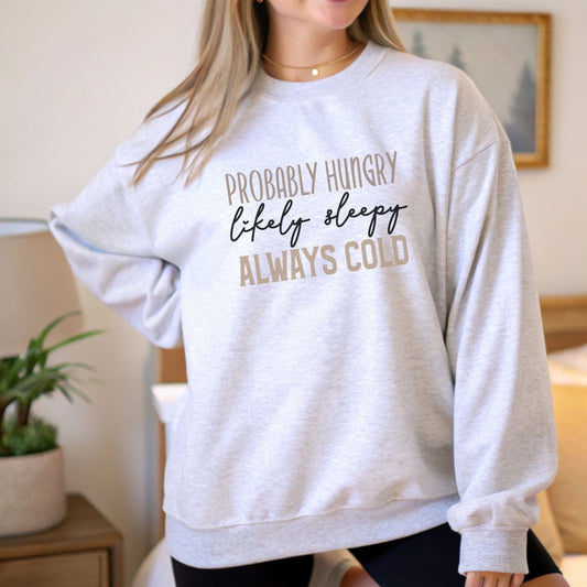 Funny “Probably Hungry, Always Cold” sweatshirt with neutral text on a cozy crewneck — perfect for comfort lovers and snack queens.