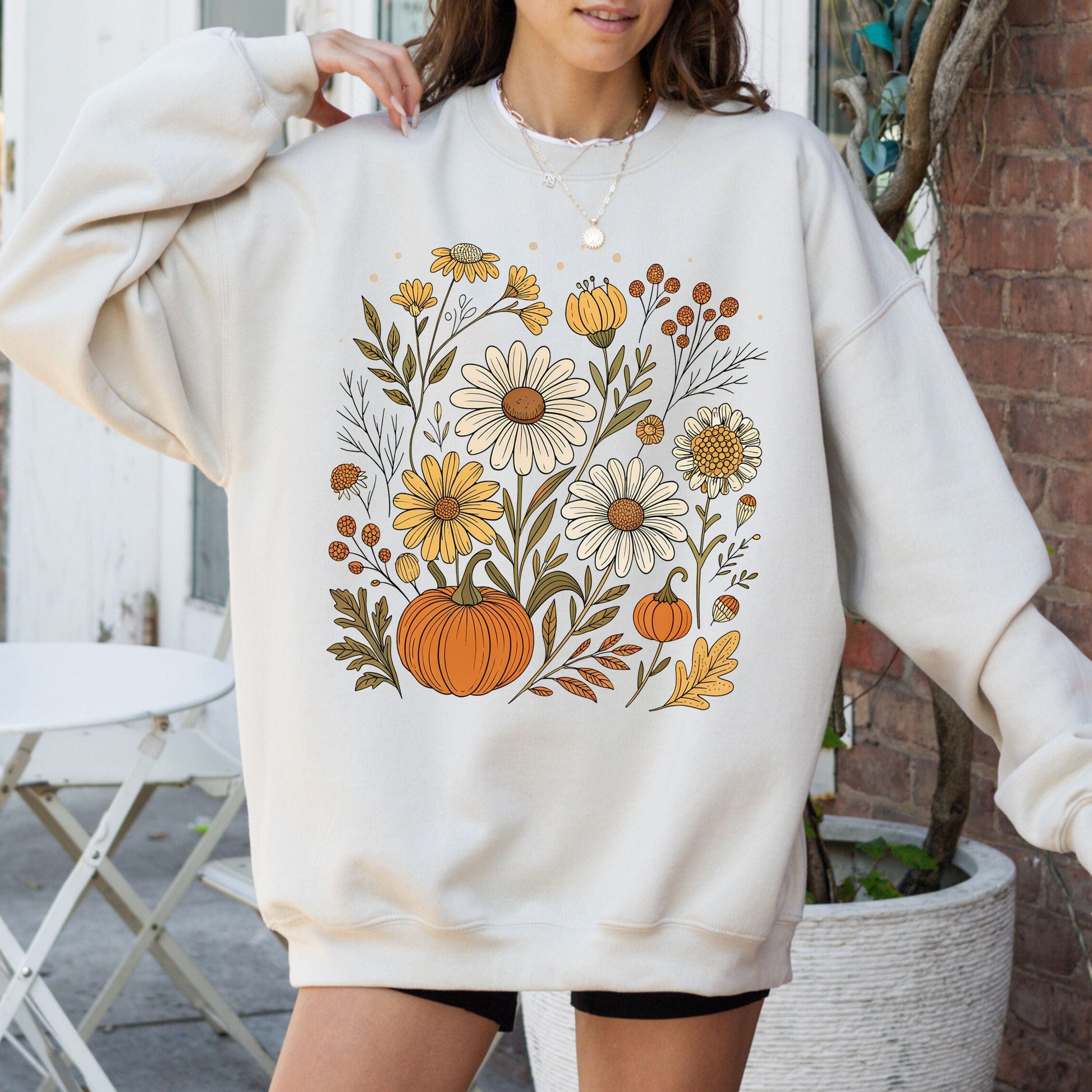 Pumpkin and wildflower fall sweatshirt in neutral tones, cozy autumn cottagecore style