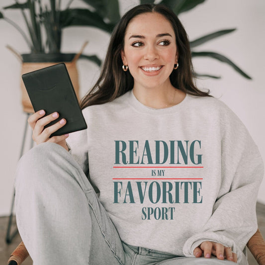 “Reading is My Favorite Sport” sweatshirt with bold varsity-style typography — cozy reader crewneck for book lovers and literary fans.