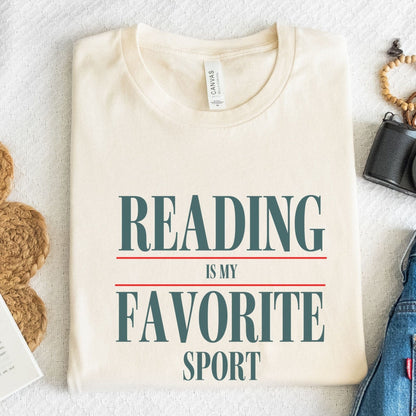 “Reading Is My Favorite Sport” t-shirt with bold serif font in dark teal and red underline accents, minimalist literary design.