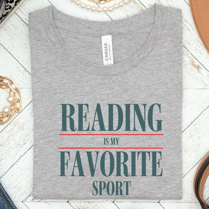 “Reading Is My Favorite Sport” t-shirt with bold serif font in dark teal and red underline accents, minimalist literary design.