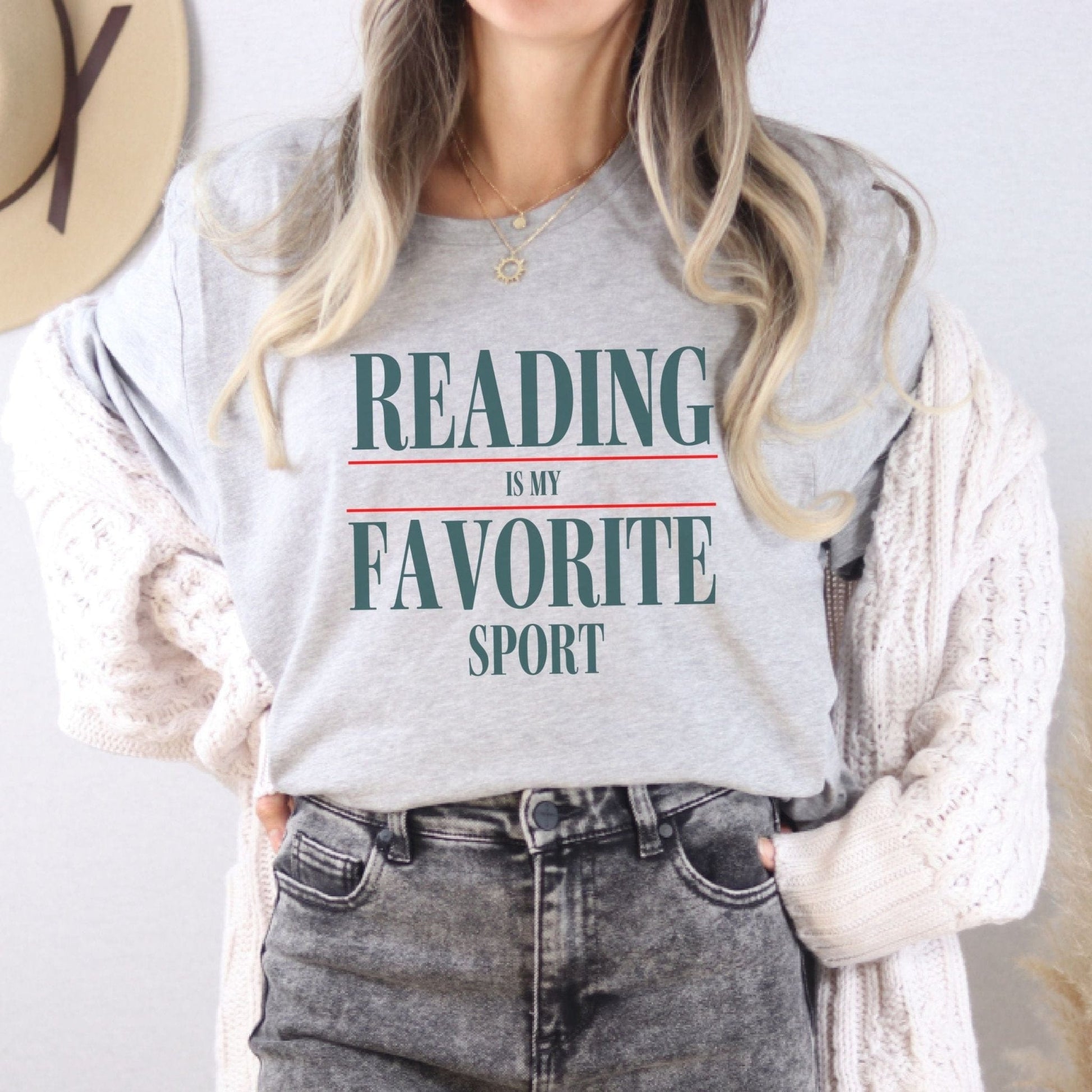 “Reading Is My Favorite Sport” t-shirt with bold serif font in dark teal and red underline accents, minimalist literary design.