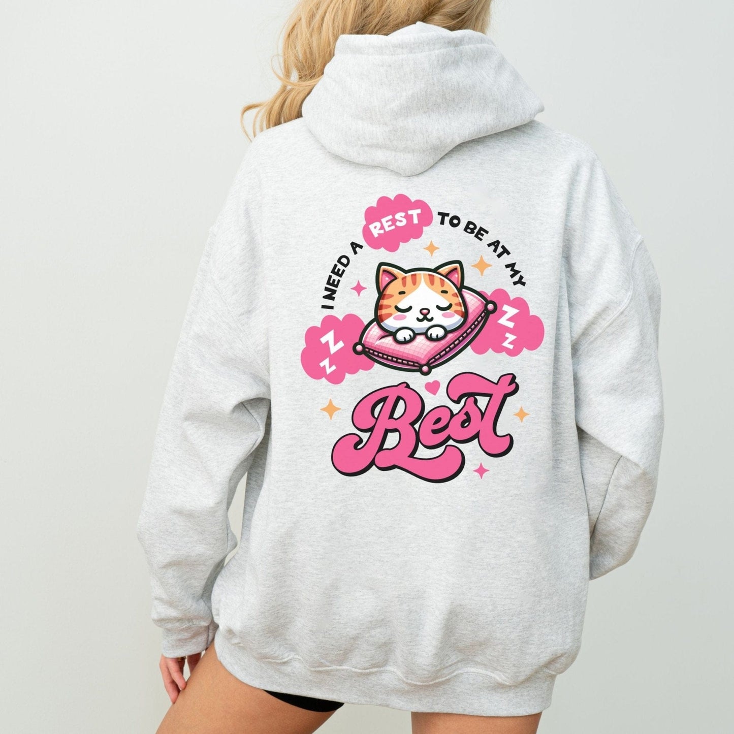 Kawaii hoodie with "Rest to Be at Your Best" back design featuring a cute cat sleeping on a pillow, and a matching mini cat graphic on the front chest.