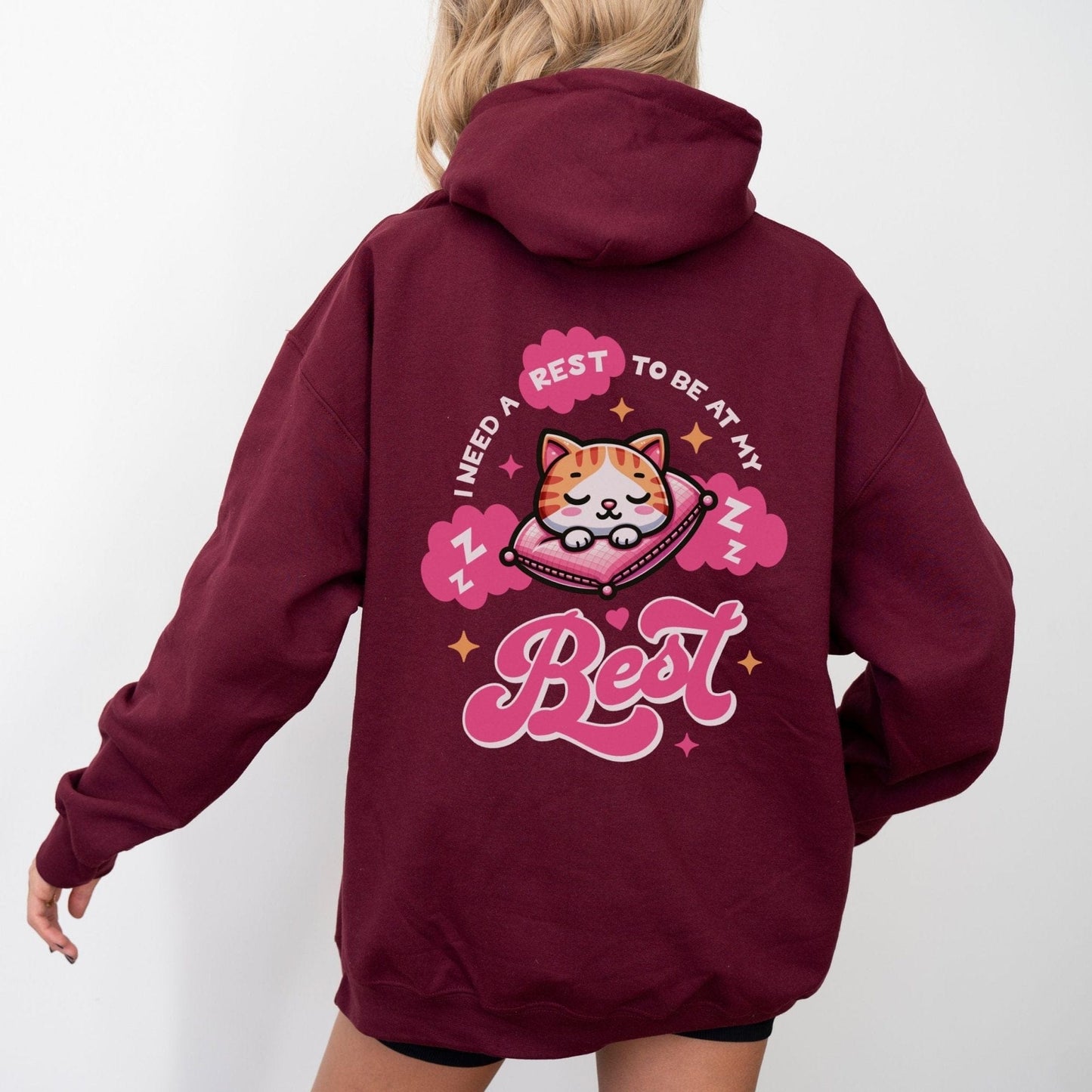 Kawaii hoodie with "Rest to Be at Your Best" back design featuring a cute cat sleeping on a pillow, and a matching mini cat graphic on the front chest.