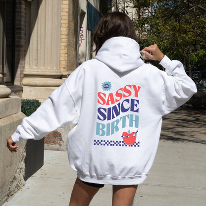 Sassy Since Birth hoodie with bold typography and colorful graphic design, cozy and available in 6 colors.