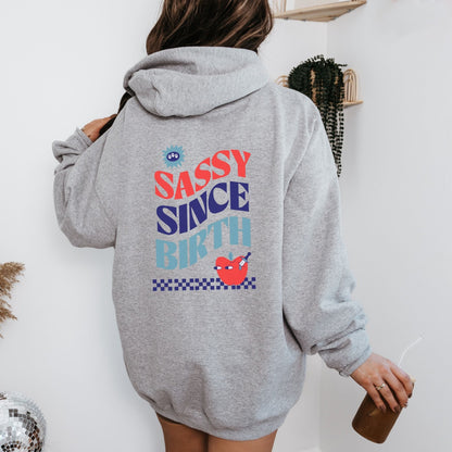 Sassy Since Birth hoodie with bold typography and colorful graphic design, cozy and available in 6 colors.