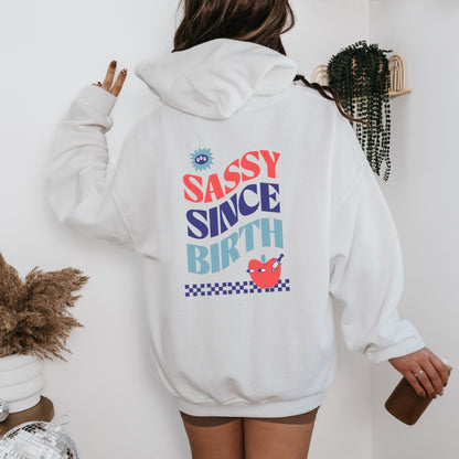 Sassy Since Birth hoodie with bold typography and colorful graphic design, cozy and available in 6 colors.