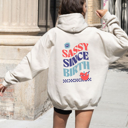 Sassy Since Birth hoodie with bold typography and colorful graphic design, cozy and available in 6 colors.