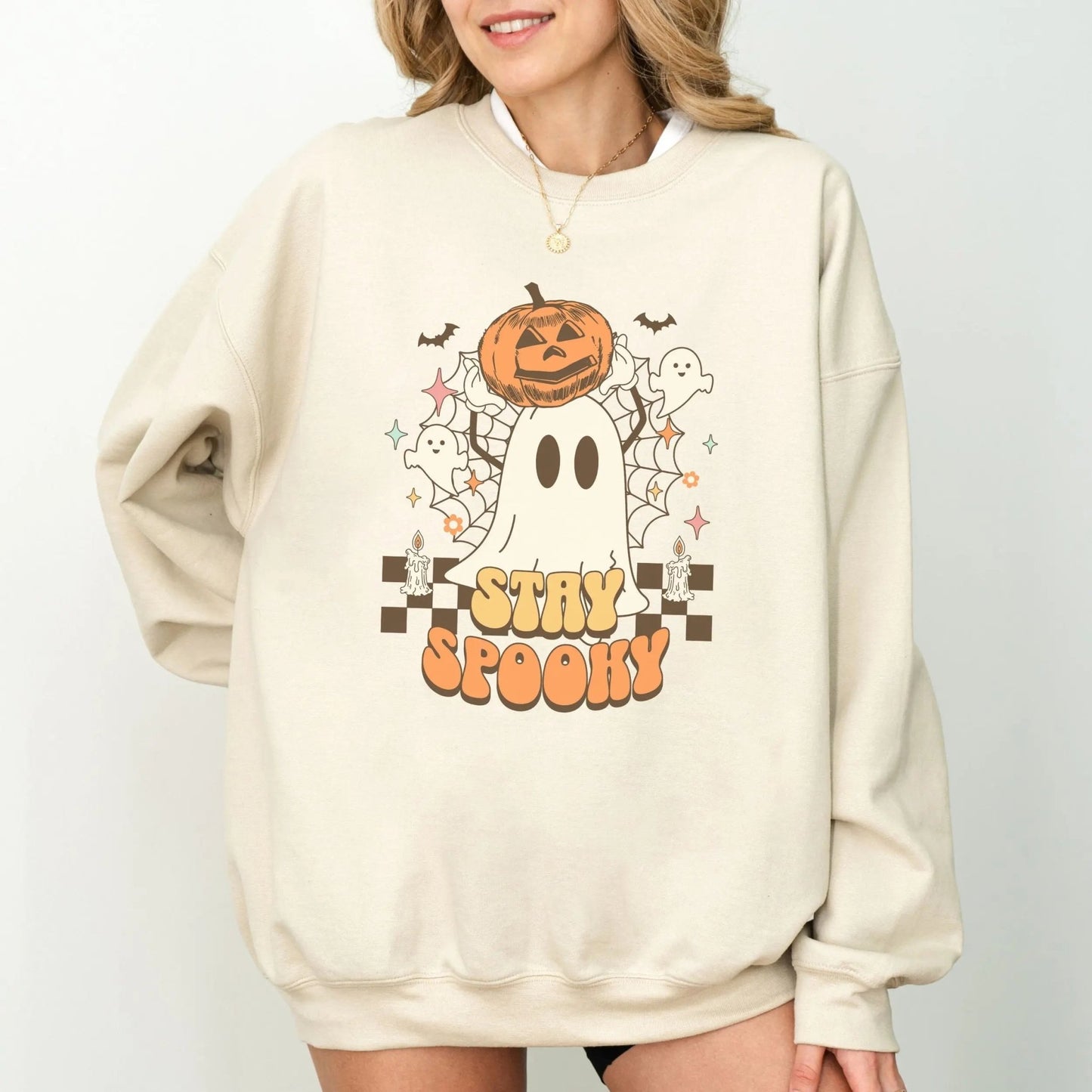 Retro "Stay Spooky" sweatshirt with ghost and pumpkin design, available in 10 colors.