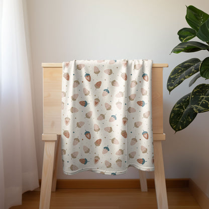 Pastel strawberry baby blanket with whimsical berry design, ideal for cozy nursery decor.