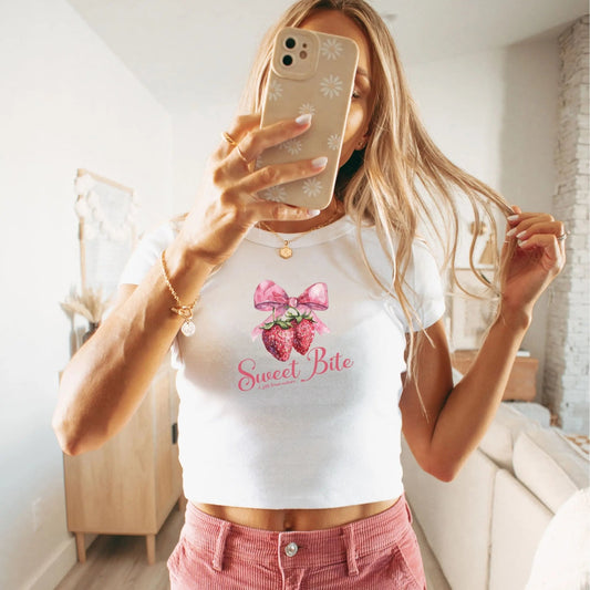 "Sweet Bite" women's baby tee with strawberry art, whimsical and cute fruit design.