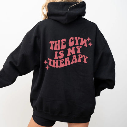 "The Gym is My Therapy" hoodie from That Cozy Vibe, available in 10 colors, fitness motivation.