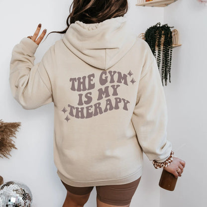 "The Gym is My Therapy" hoodie from That Cozy Vibe, available in 10 colors, fitness motivation.