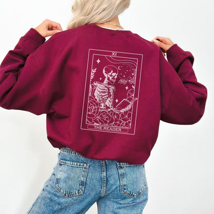 “The Reader Tarot” sweatshirt with mystical tarot card illustration printed on the back, perfect for book lovers and cozy fall vibes.