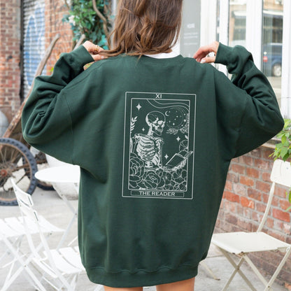 “The Reader Tarot” sweatshirt with mystical tarot card illustration printed on the back, perfect for book lovers and cozy fall vibes.