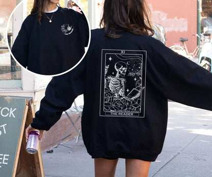 “The Reader Tarot” sweatshirt with mystical tarot card illustration printed on the back, perfect for book lovers and cozy fall vibes.