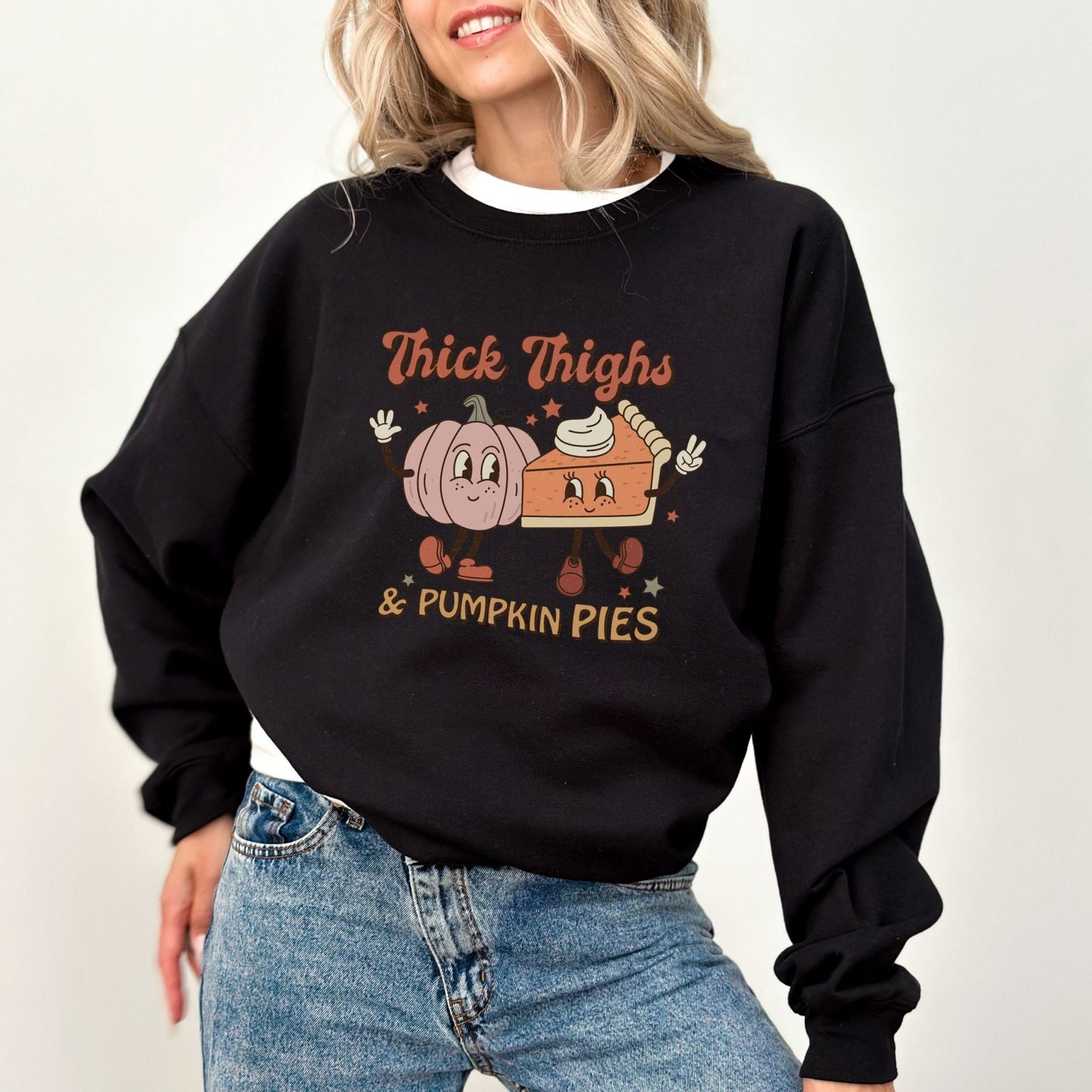 Thanksgiving sweatshirt with "Thick Thighs & Pumpkin Pies" graphic featuring pumpkin and pie characters.