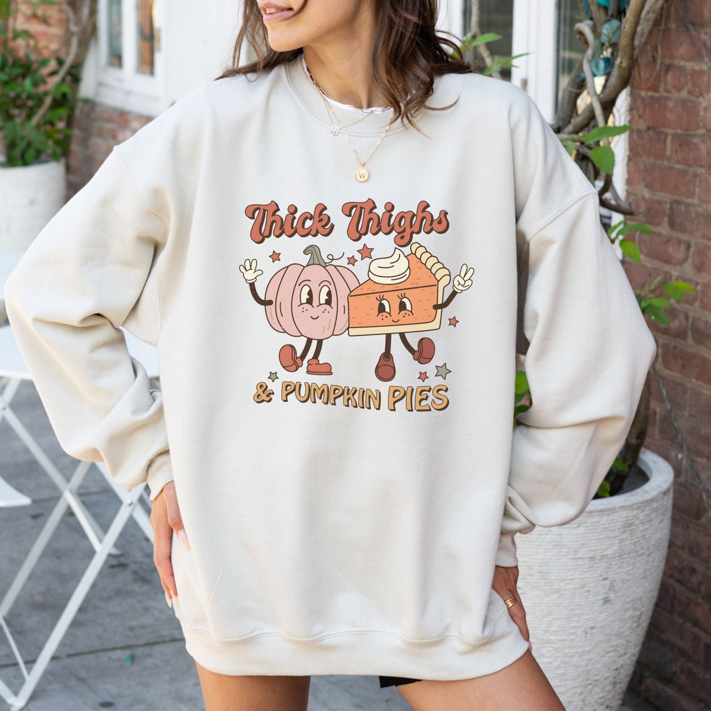 Thanksgiving sweatshirt with "Thick Thighs & Pumpkin Pies" graphic featuring pumpkin and pie characters.