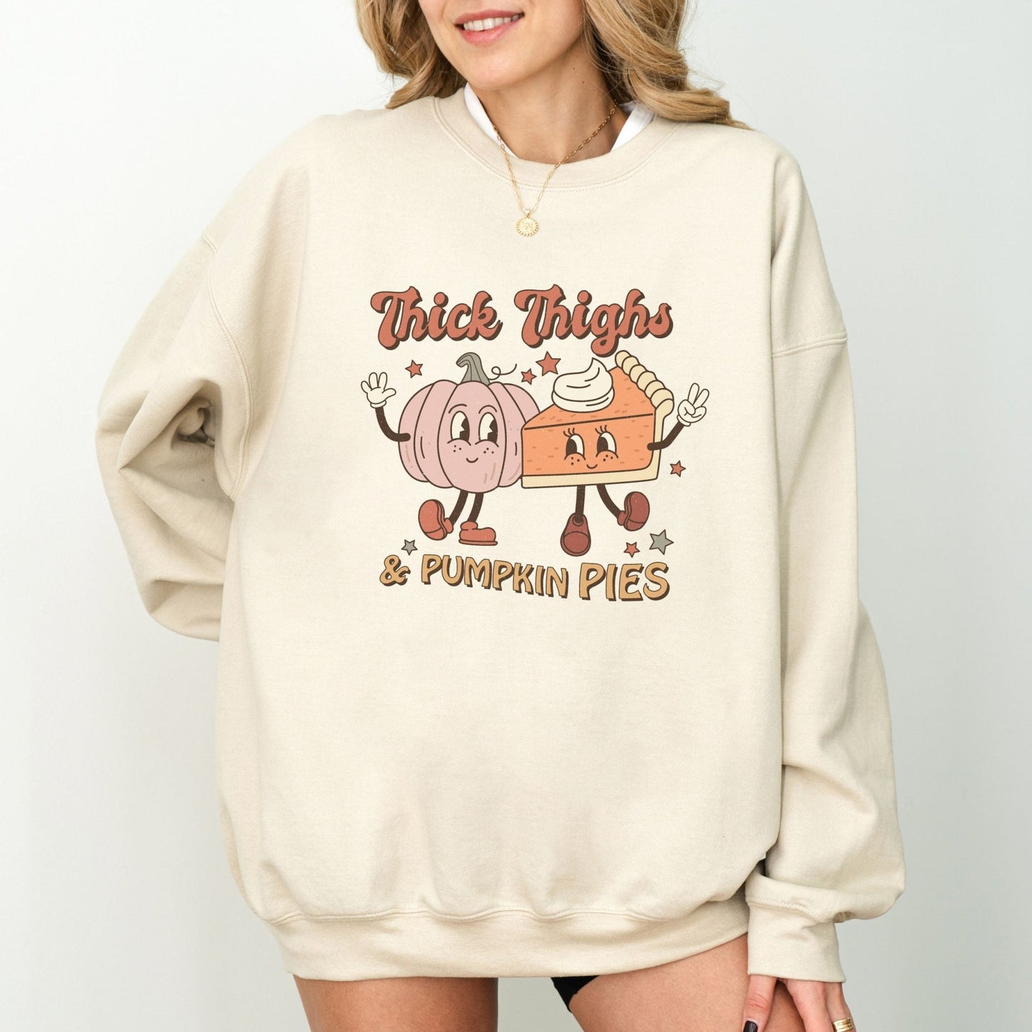 Thanksgiving sweatshirt with "Thick Thighs & Pumpkin Pies" graphic featuring pumpkin and pie characters.