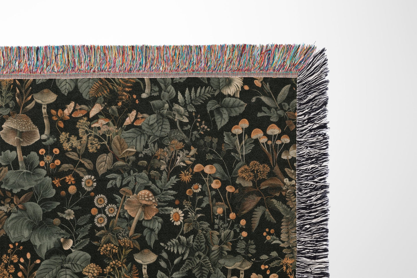 Woodland botanical fringe blanket with mushroom and wildflower print, cozy cottagecore decor.