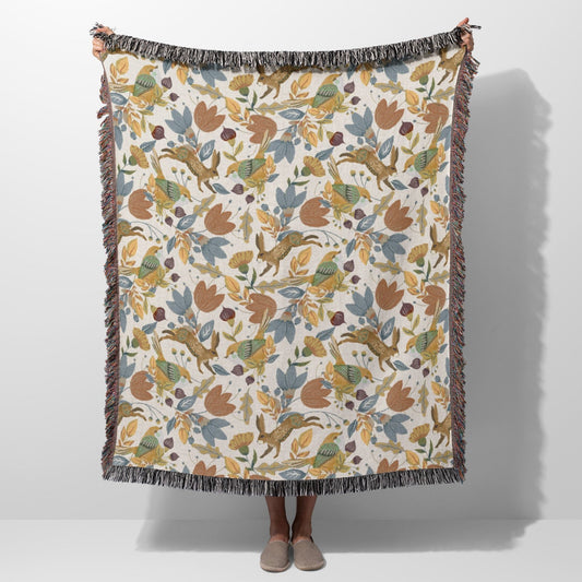 Nature-inspired woven blanket with earthy floral and bird design.